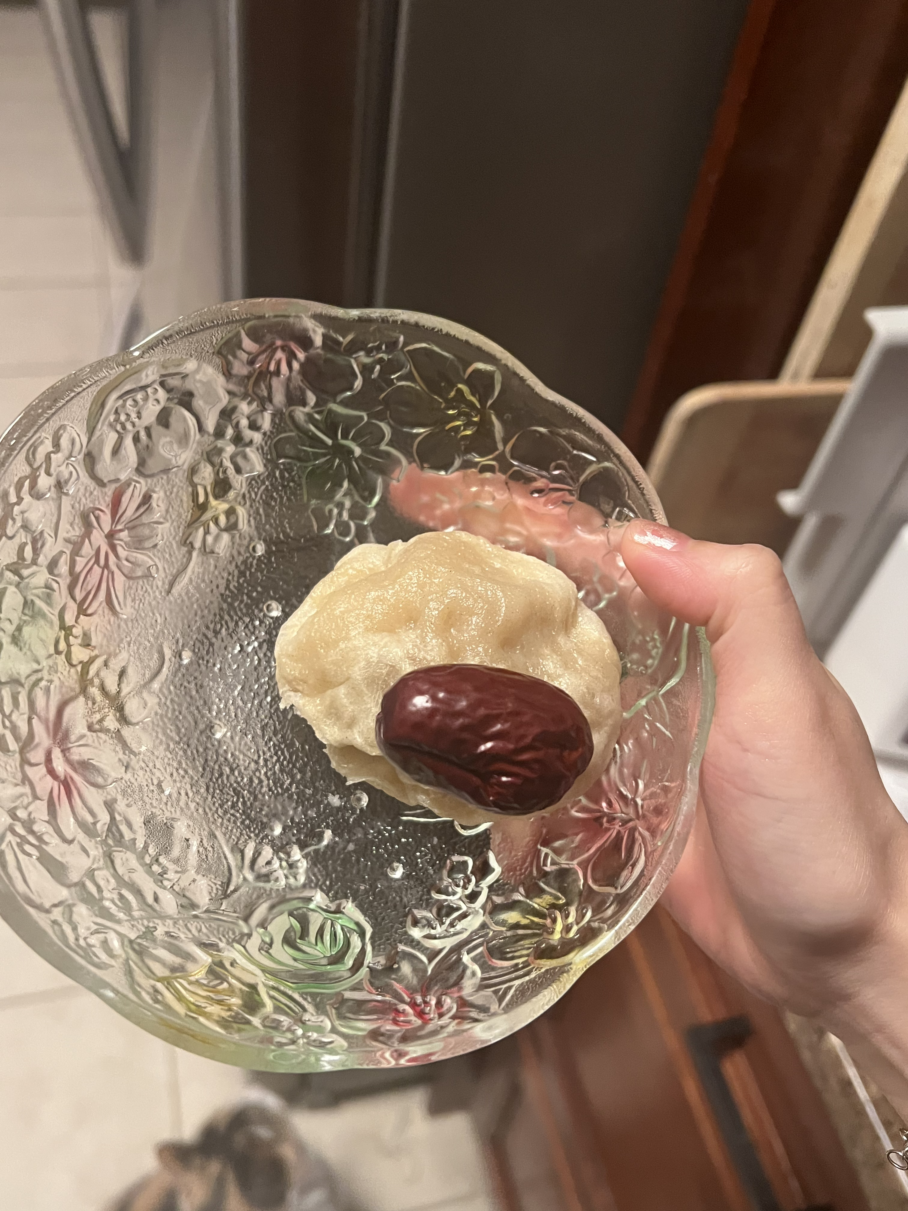 me holding a lumpy steamed bun with a date on top the same size as the bun